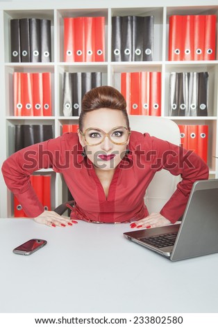 Suspicious woman boss in eyeglasses looking at you