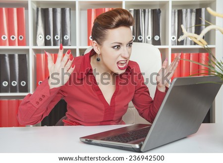 Angry screaming business woman working with computer