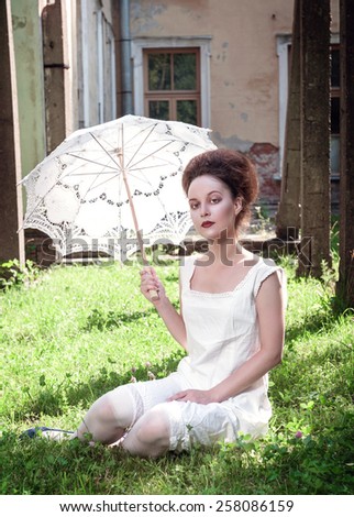 Beautiful young gothic girl in white shirt with umbrella outdoor
