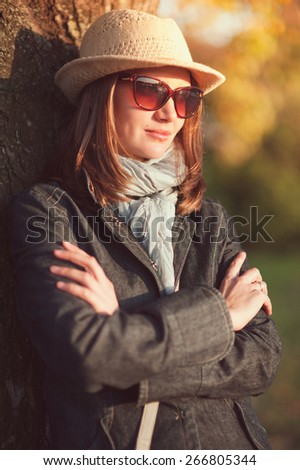 Beautiful young woman in hat and scarf enjoy sunlight outdoor