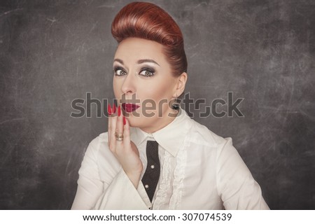 Beautiful woman with a confused expression on the blackboard background