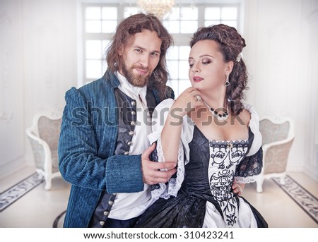 Beautiful couple woman and man in medieval clothes in the room