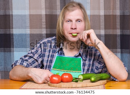 Man with piece of cucumber in the mouth