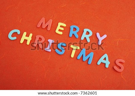 Merry christmas text (colorful soft rubber  letters) on red silk paper