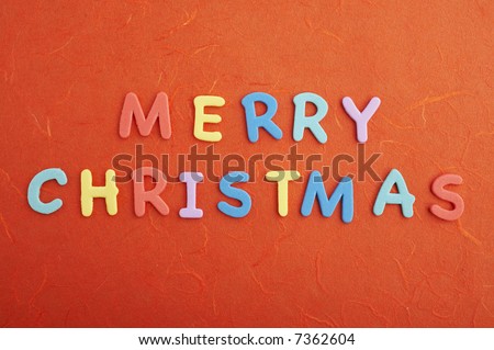 Merry christmas text (colorful soft rubber letters) on red silk paper