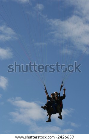Tandem paragliders in mid air