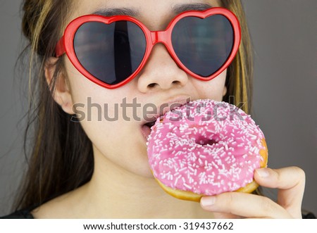 Sexy woman with red lolita glasses eating donut.