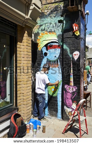 LONDON,UK- JUNE 08: Graffiti artist paints the wall on Brick Lane on June 08, 2014 in London.