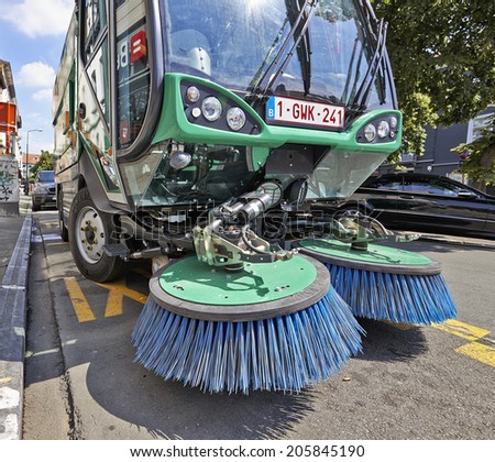 BRUSSELS, BELGIUM - JULY 17, 2014: Process of urban street cleaning. Municipal machanical truck at Square du Chatelain in Ixelles on July 17 in Brussels.