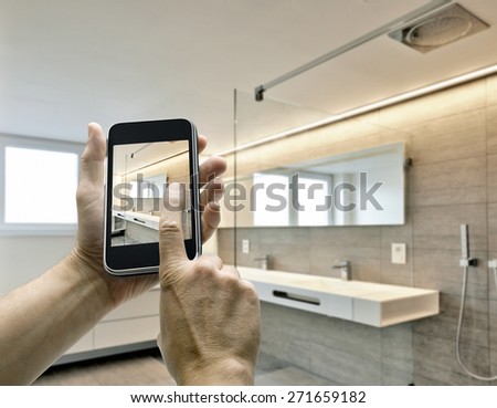 Mobile device with man hands taking picture in luxury Bathroom