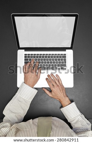 Businessman wearing a white shirt and green tie working on his laptop. Reflection screen like a mirror and blank screen