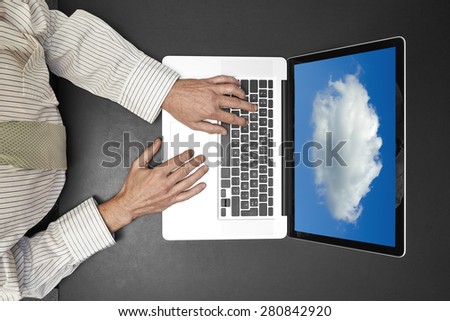 Businessman wearing a white shirt and green tie working on his laptop. Cloud computing on screen