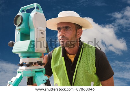 civil engineer doing land survey at a construction site, close up of surveyor working on theodolite
