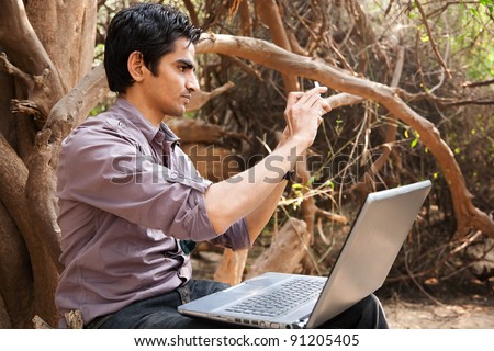 remote connectivity, man sitting under the trees in jungle and working on the laptop, Indian man.