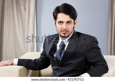 confident Indian businessman sitting on sofa