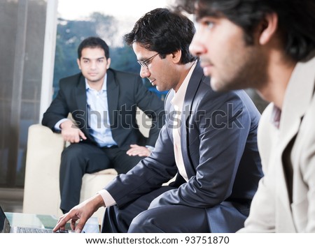 indian businessman explaining on laptop in meeting