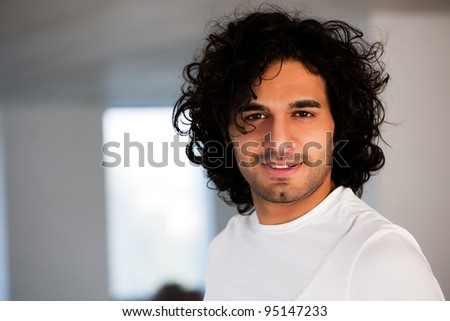 portrait of happy confident man with curly hair, portrait of confident hispanic man with copy space.