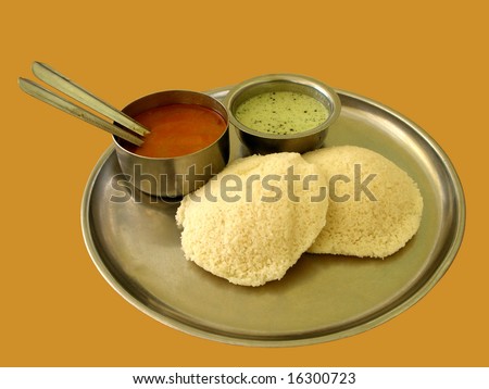 Closeup of an indian breakfast known as idly, which is cooked in steam and is served with chutney and curry.  Idly is a zero-cholesterol, healthy breakfast.