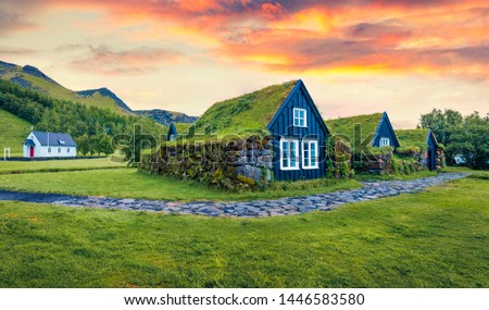 Typical view of turf-top houses in Icelandic countryside. Dramatic summer sunrise in Skogar village, south Iceland, Europe. Traveling concept background. 商業照片 © 