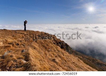 Photographer makes the photo above the clouds in the mountains