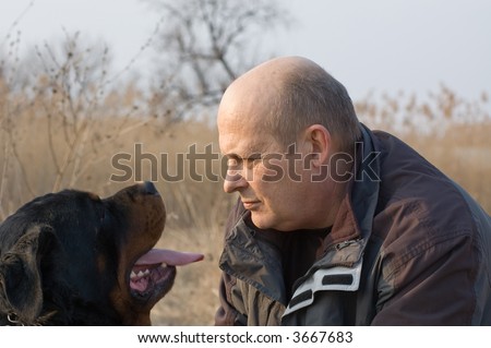 man and rottweiler dog face to face
