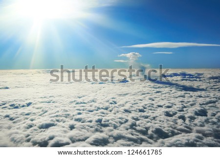 Blue sky, sun and clouds. Plane view above the earth, can be used for background