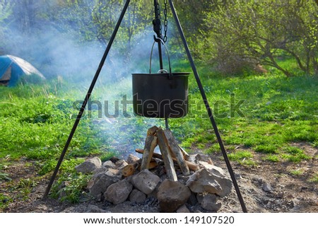 Pot boiling on fire. Fireplace in the forest.