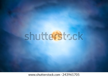Night view at the full moon through moving blue clouds. Abstract scene