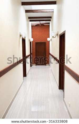 Light hall with marble flour and the door at the end oh corridor