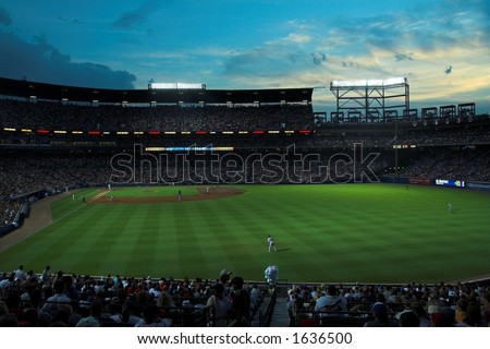 Turner Field, home of the Atlanta Braves, during a night game with capacity crowd; set against a brilliant blue sky