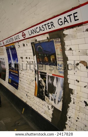 aged London underground station wall with ad posters