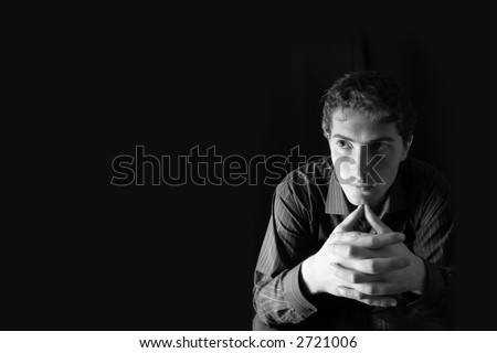 Pensive man. Black background. Space