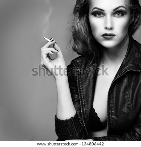 a portrait of beautiful sexual redheaded girl is in a black leather jacket, smoking a cigarette