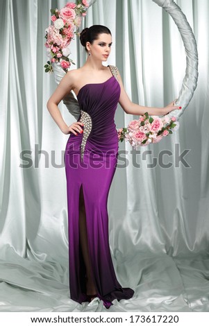 Beautiful brunette in n evening dress with the hoop with pink flowers