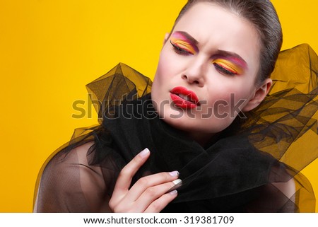 Portrait of sexual young girl in a black veil on a yellow background
