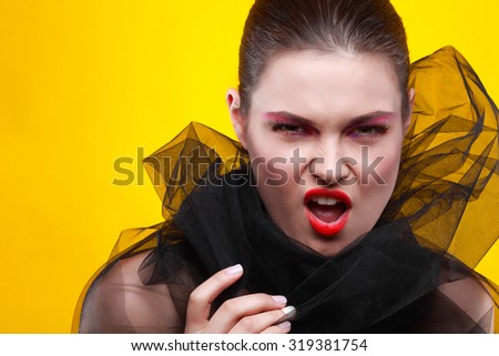 Portrait of sexual young girl in a black veil on a yellow background