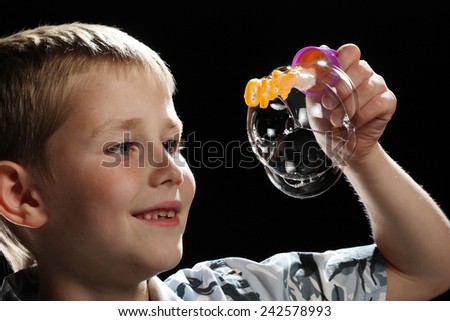 Portrait of cute little boy making soap bubbles.