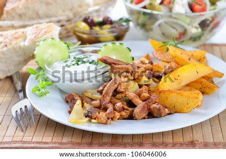 Greek gyros with fried potatoes and tzatziki, served with pitabread an Greek salad