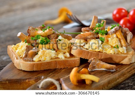 Breakfast with scrambled eggs and fresh fried chanterelles on toast