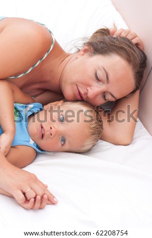 Mother with little son lies on bad