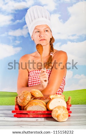 young woman in a chef\'s hat - it bread, cooking, drinking milk, on background of the sky - picnic