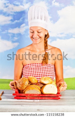 young woman in a chef\'s hat - it bread, cooking, drinking milk, on background of the sky - picnic