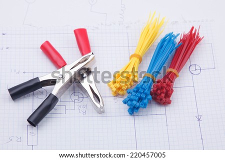 Electric clamps and plastic ties on a background of the electric scheme