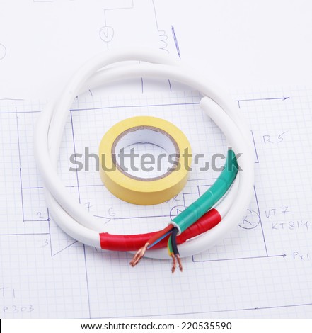 Adhesive plastic tape and electric cable on a background of the electric scheme