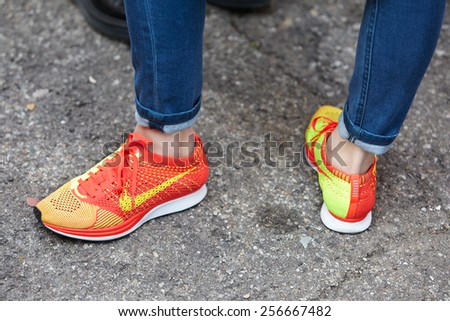 MILAN - FEBRUARY 25: Woman poses for photographers with orange Nike shoes  before show Milan Fashion Week Day 1, Fall/Winter 2015/2016 street style  day 1, on February 25, 2015 in Milan. - Stock Image - Everypixel