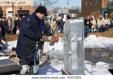 An artist cuts into a block of ice at an ice carving competition