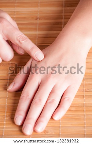 Acupressure, acupuncture point Hegu, LI4. Photo shows how to find this point.