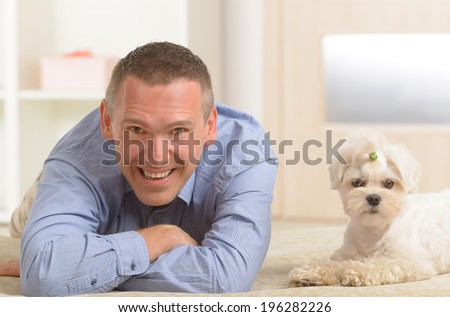 Little dog maltese with his owner on the sofa in home