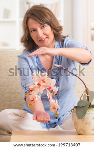 Woman doing Reiki therapy for a flower, a kind of energy medicine.