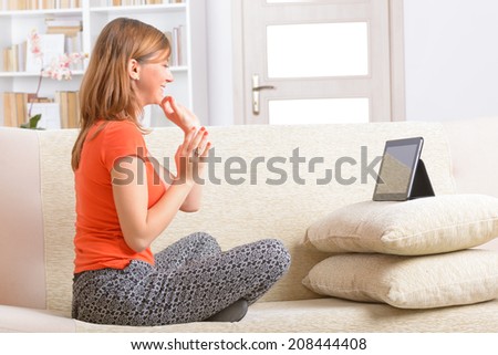 Smiling Deaf woman talking using sign language on the tablet